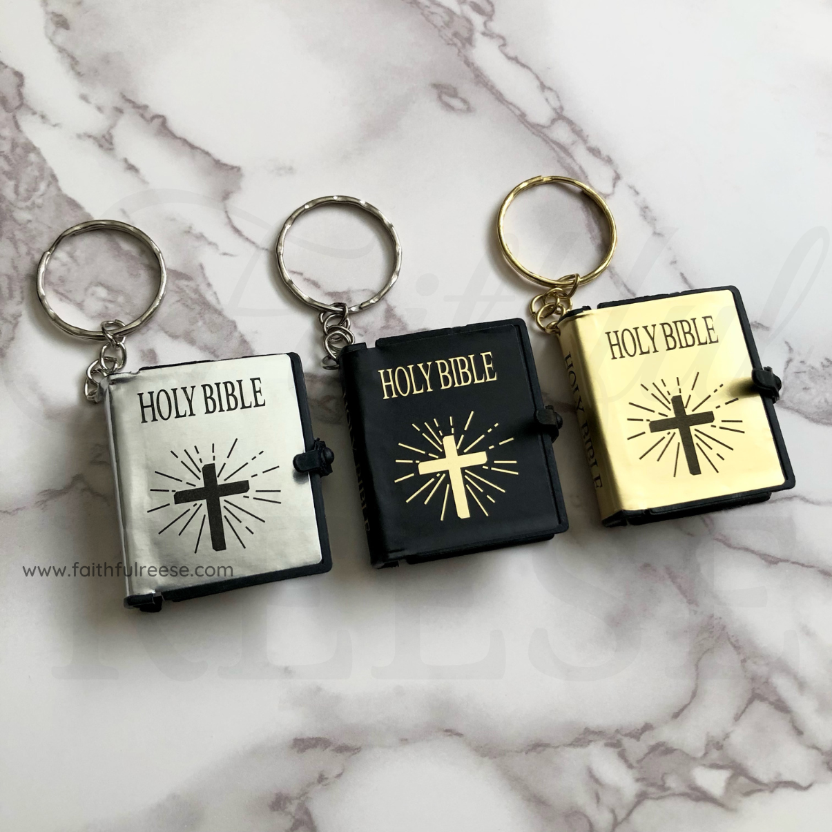 Mini bible keychains in silver, black, and gold.